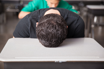 Frustrated high school student with his head resting face down on his desk