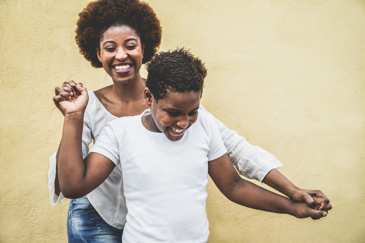 Mom joyfully dancing with her adolescent with ADHD