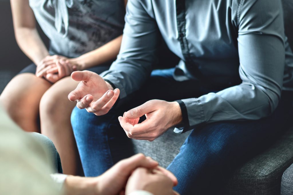 Picture of a neurodiverse family meeting, focusing on hands and body language