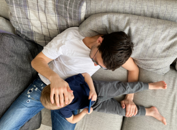 father soothing his kid on the couch
