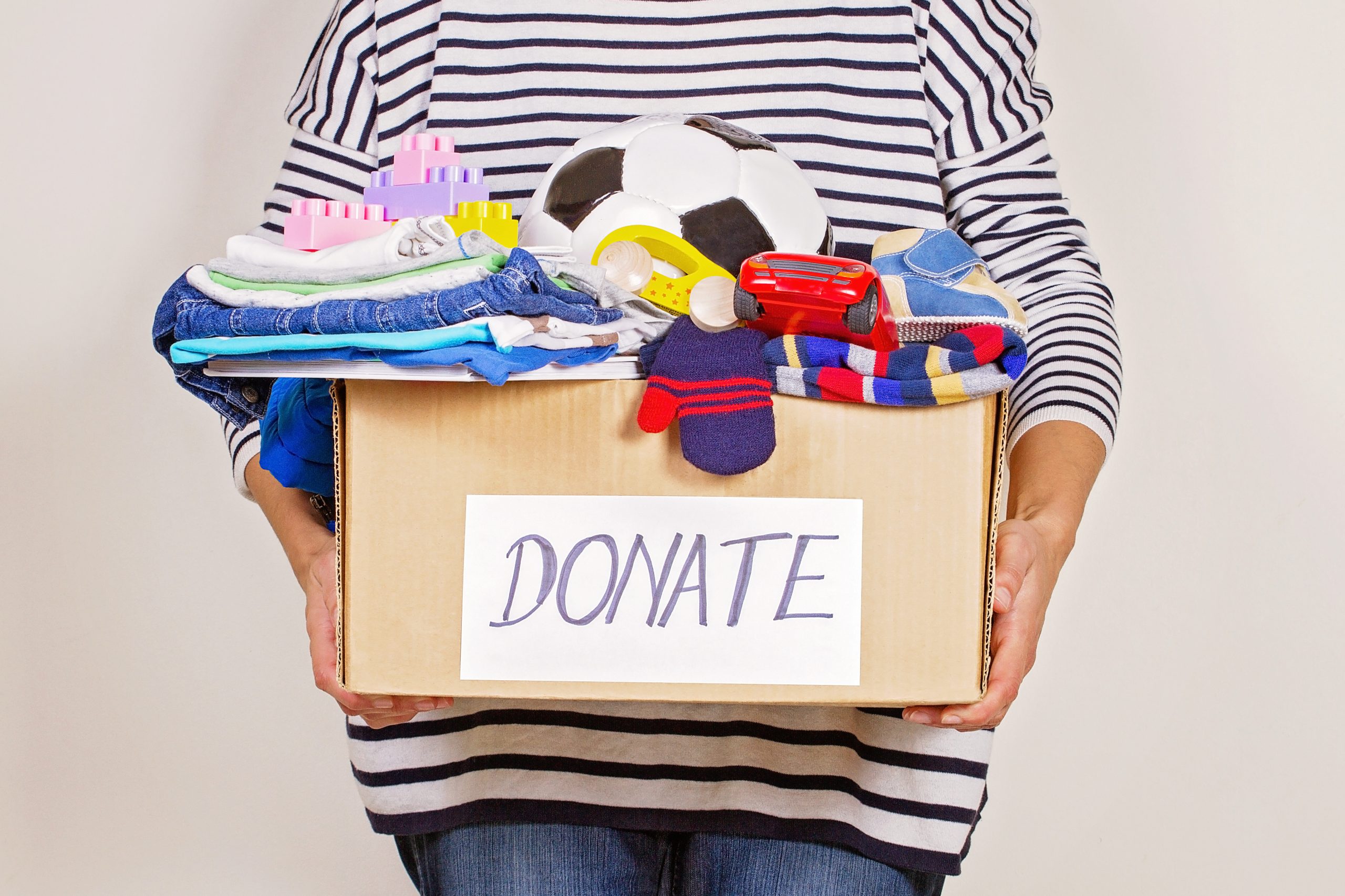 woman holding donation box with clothes to give to charity