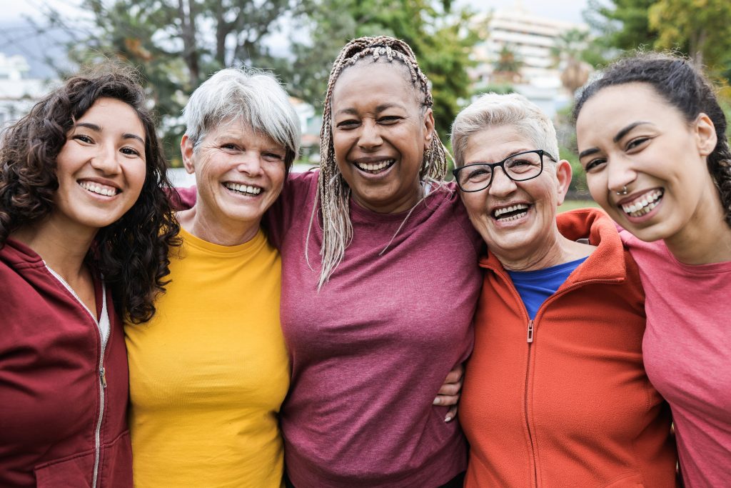 5 women smiling and hugging