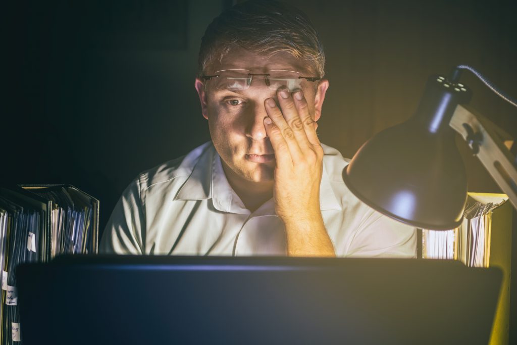 Man with tired eyes due to too much work on the computer screen