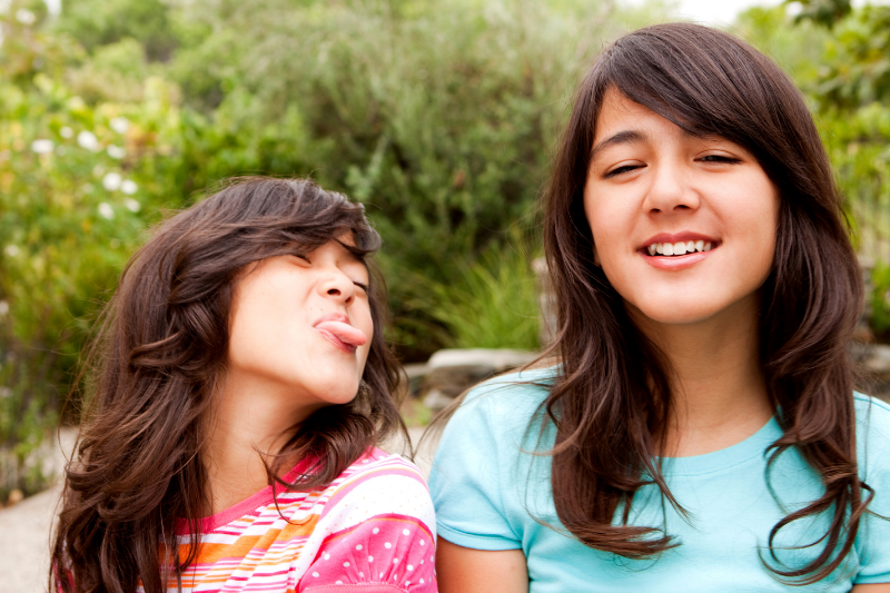 girl sticking tongue out at laughing friend