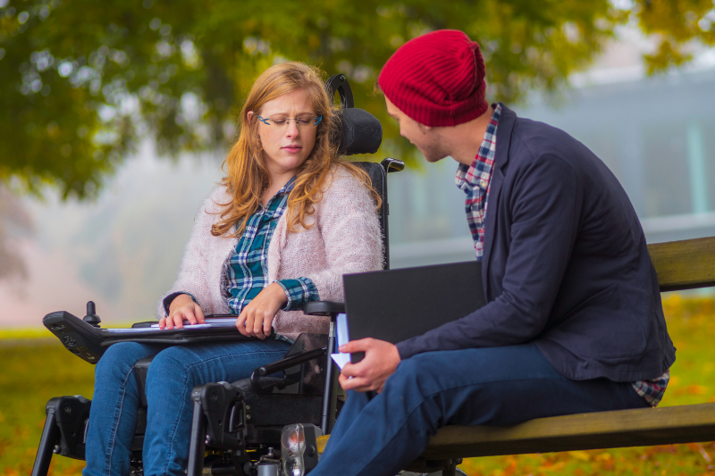 teen boy talking to girl in wheelchair