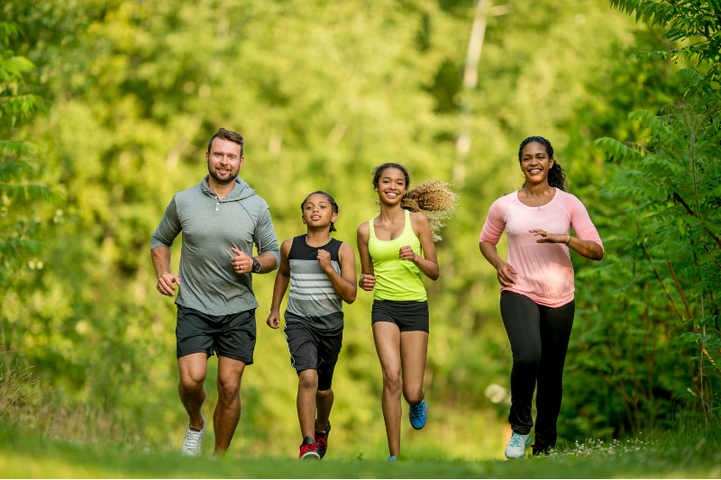 parents and two kids jogging in the park