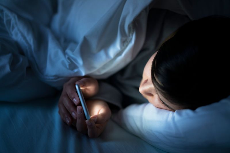 Kid using phone at night in bed