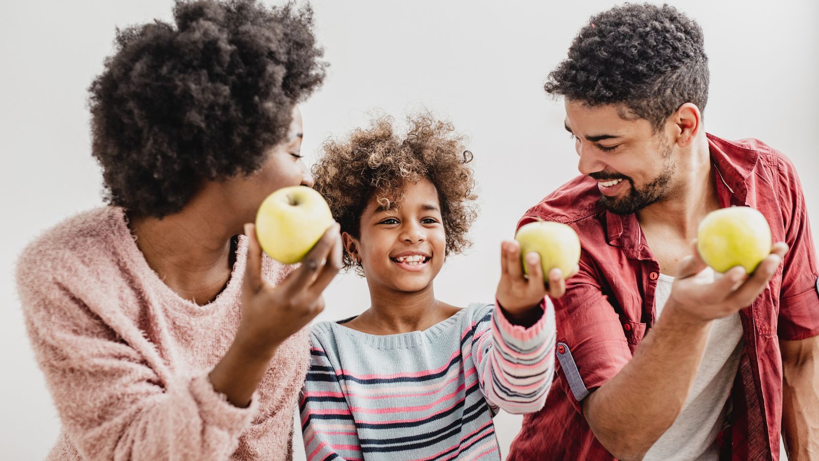 Mom, Dad and Kid holding an apple