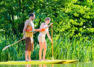 Woman and man paddling on stand up boat