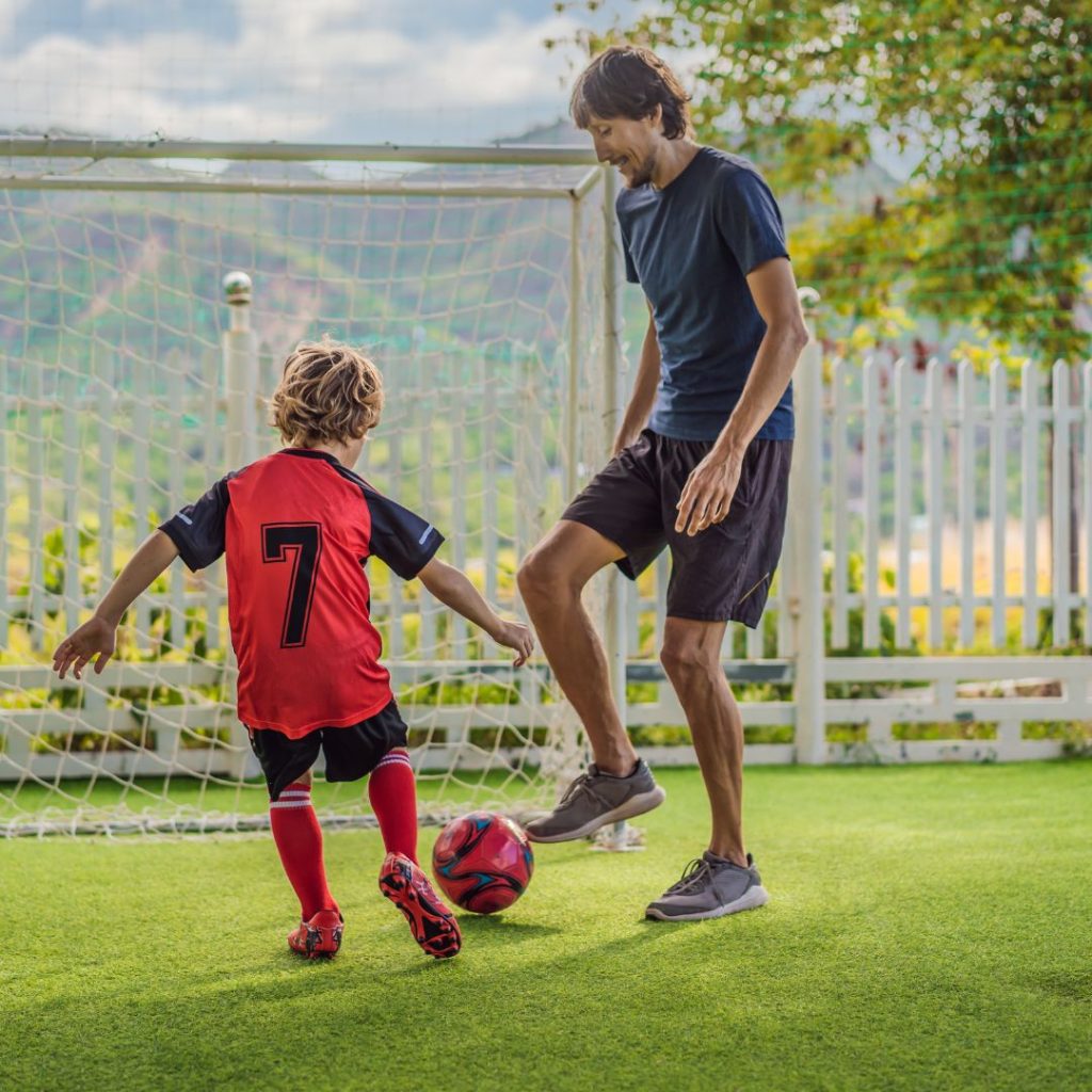 Father and son playing soccer