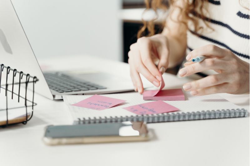 woman's hands at desk with post-it notes