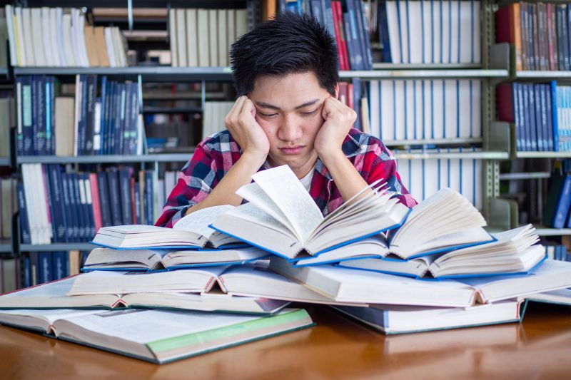 unhappy student looking at books